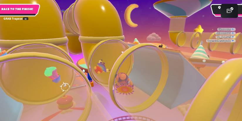 a fall guy bean in a colorful costume floating through a large, yellow pipe