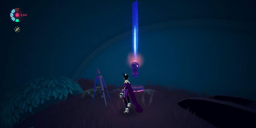 a purple caped, armored figure looks a small, floating object with a pink light on the front and top that is also shooting a blue light straight up 