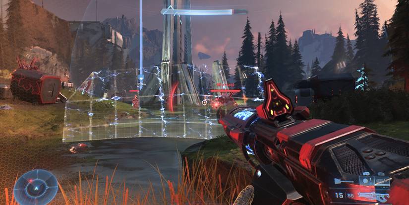 the master chief stands behind a yellow barrier with electricity coursing through it in the middle of a battle