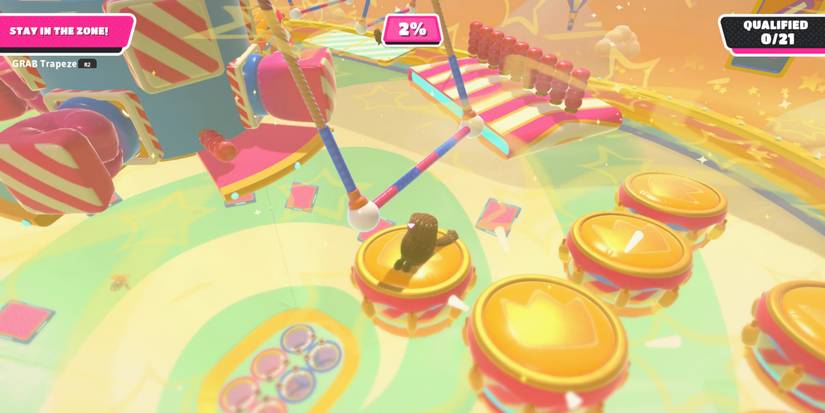 a brown fall guy bean dives toward a gold-topped drum in the distance