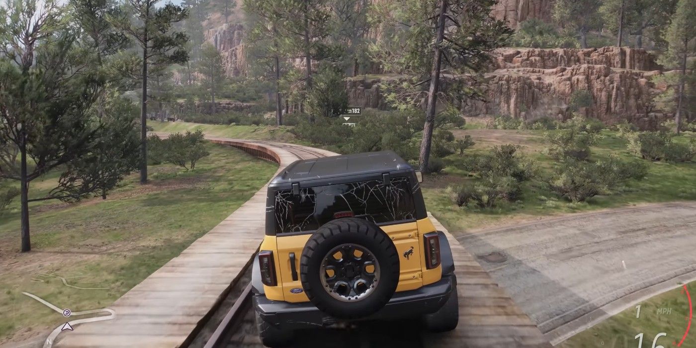 Forza Horizon 5 driving on train tracks in mountainous cliff region with growth