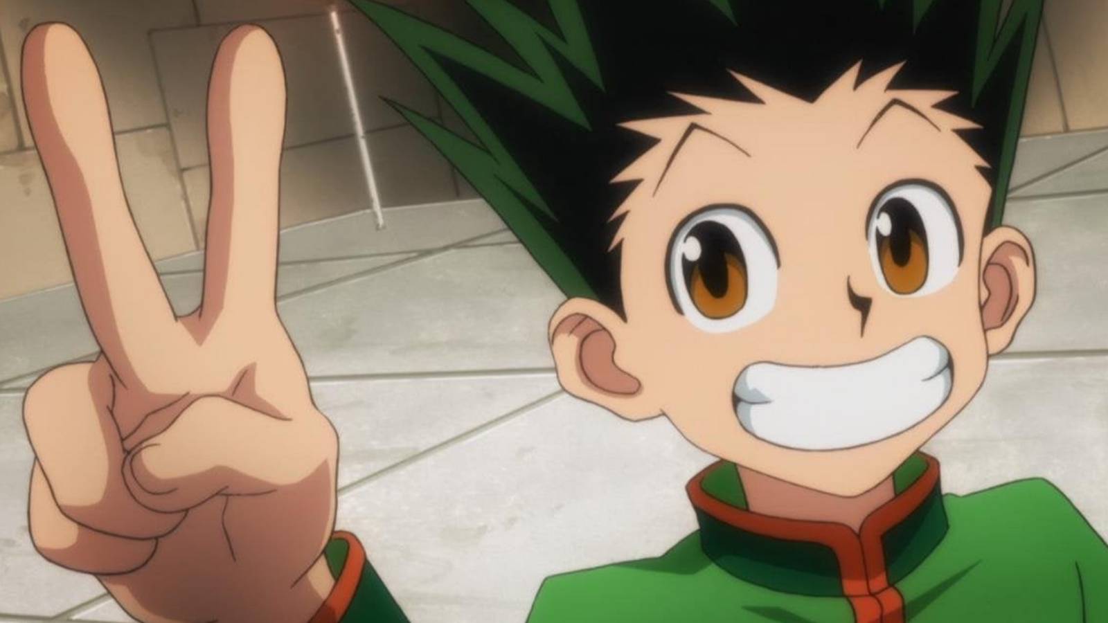 Gon Freecss smiling widely and holding a Peace sign