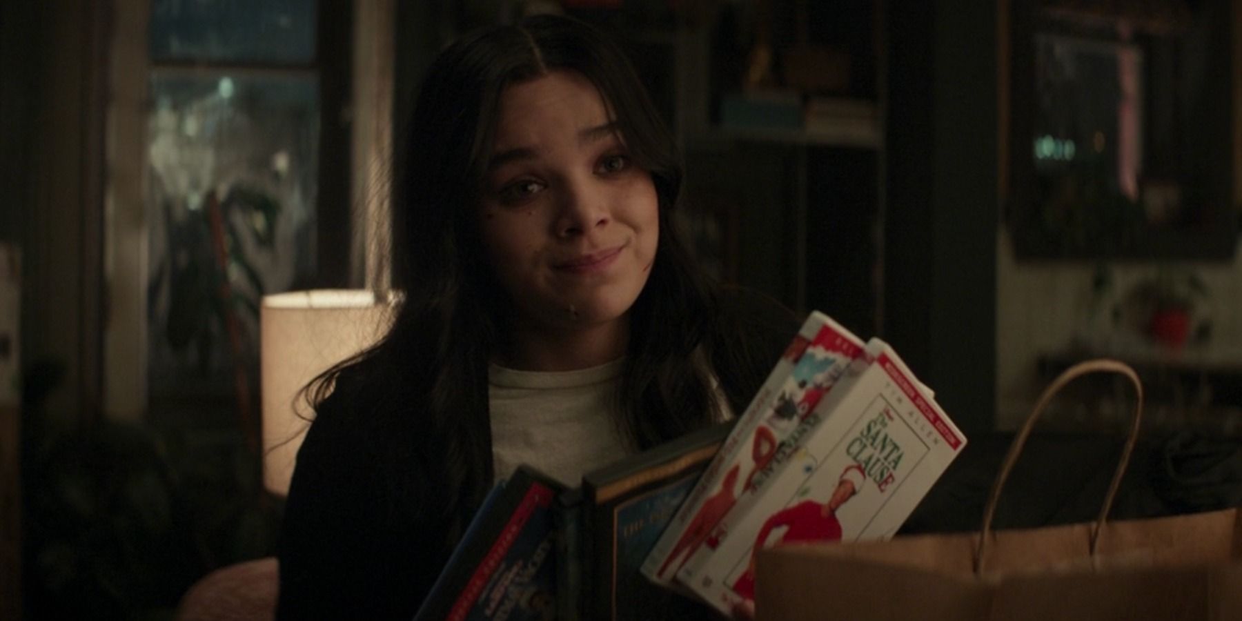 Kate Bishop holds a stack of holiday movies in Hawkeye Episode 4