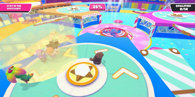 a fall guy bean on a green, rotating track with a golden spotlight to the left