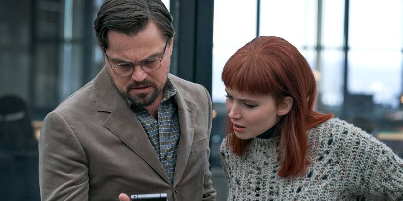 Leonardo DiCaprio and Jennifer Lawrence looking at a phone in Don't Look Up