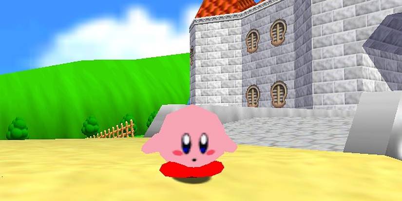 Kirby standing in front of Peach's castle in Mario 64 fan mod