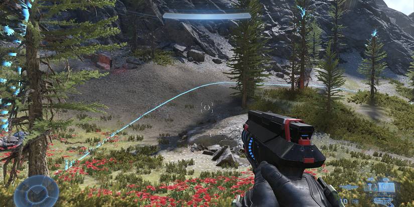 the master chief standing in a forest with a faint blue hemisphere around him and the nearby trees