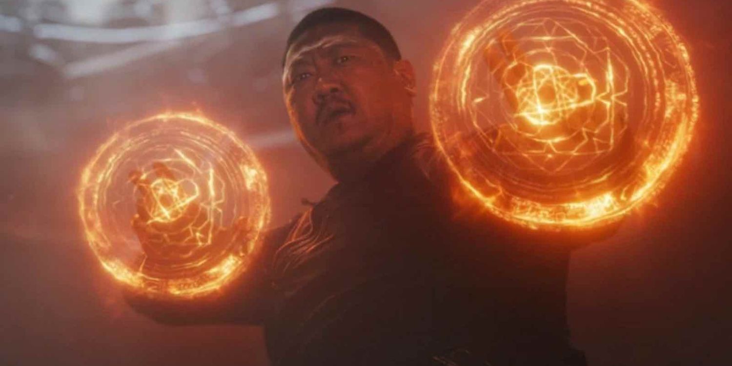 wong, a heavy-set Asian man with short-cropped hair and a mustache, holds magical wards over both his hands