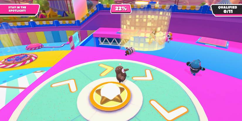 a fall guy bean on a green, rotating track with a golden spotlight behind it 