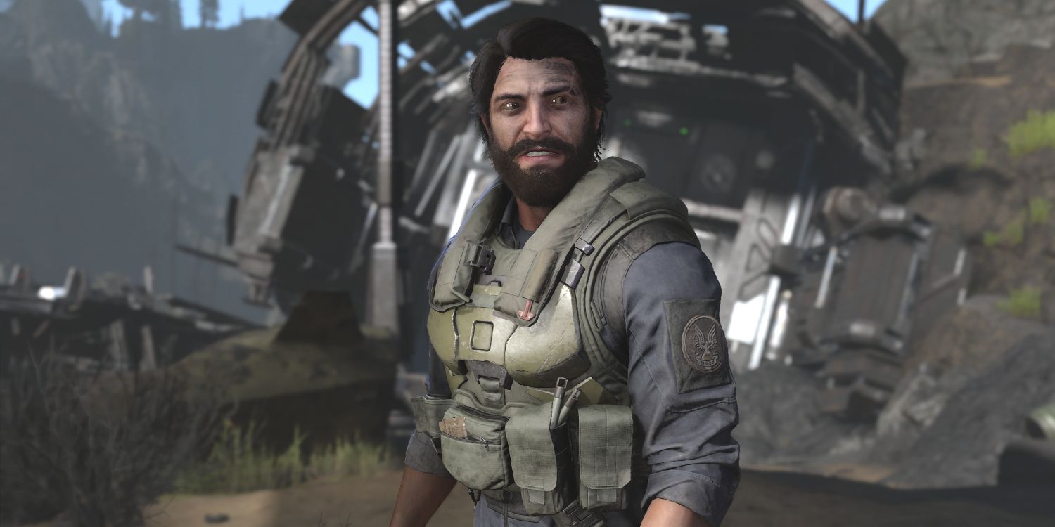 a man in a military vest and shirt with thick dark hair and a beard stands in front of the wreckage of spaceship
