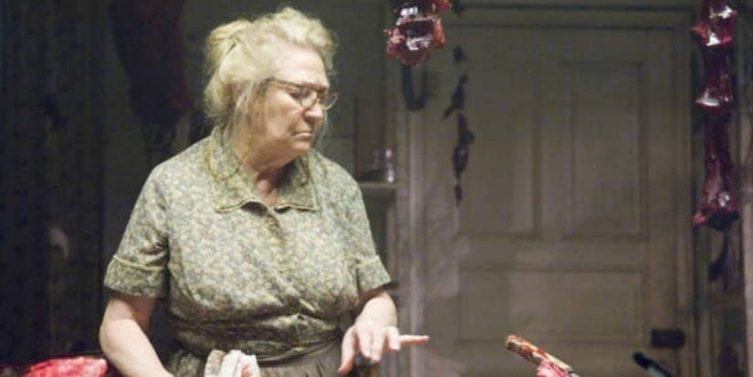 Luda May from The Texas Chain Saw Massacre standing at the table