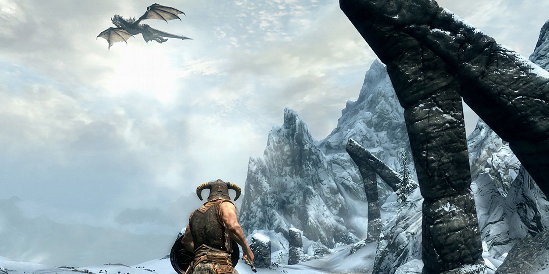 Screenshot from The Elder Scrolls 5: Skyrim showing the Dragonborn looking up at a dragon in the wintry sky.