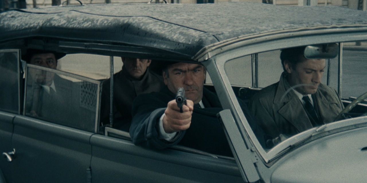 A spy firing a gun from a car window in Army of Shadows
