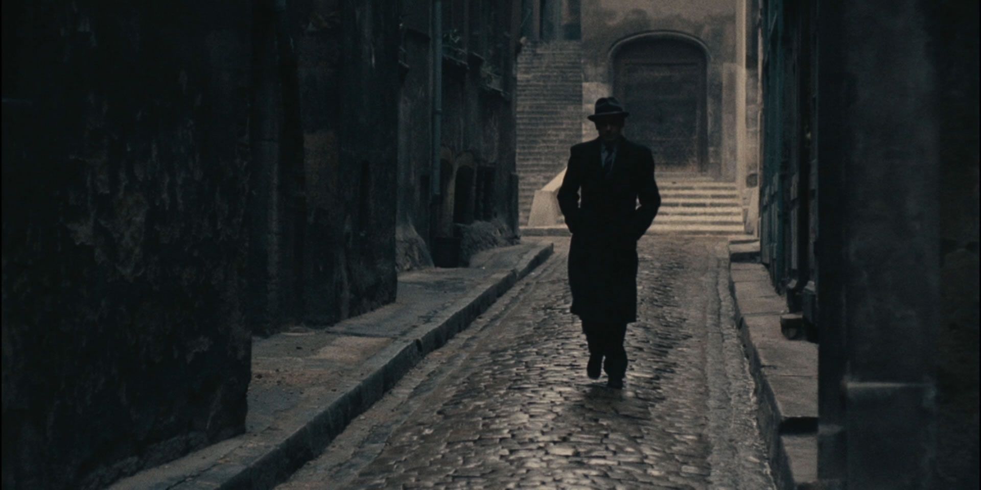 A spy walks down an alley in Army of Shadows