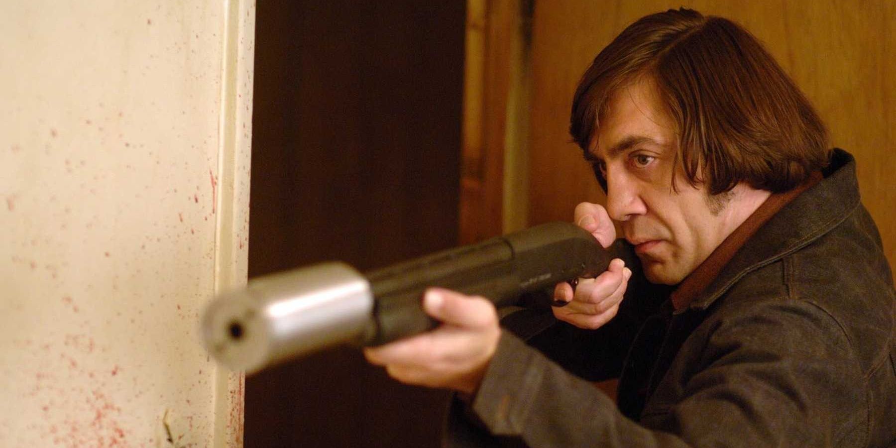 Javier Bardem as Anton Chigurh holds a silences shotgun in the film No Country For Old Men