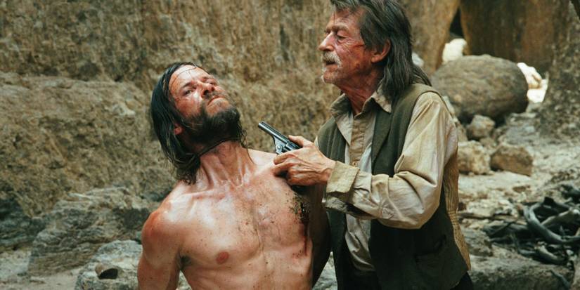 John Hurt holds Guy Pearce at gunpoint in The Proposition