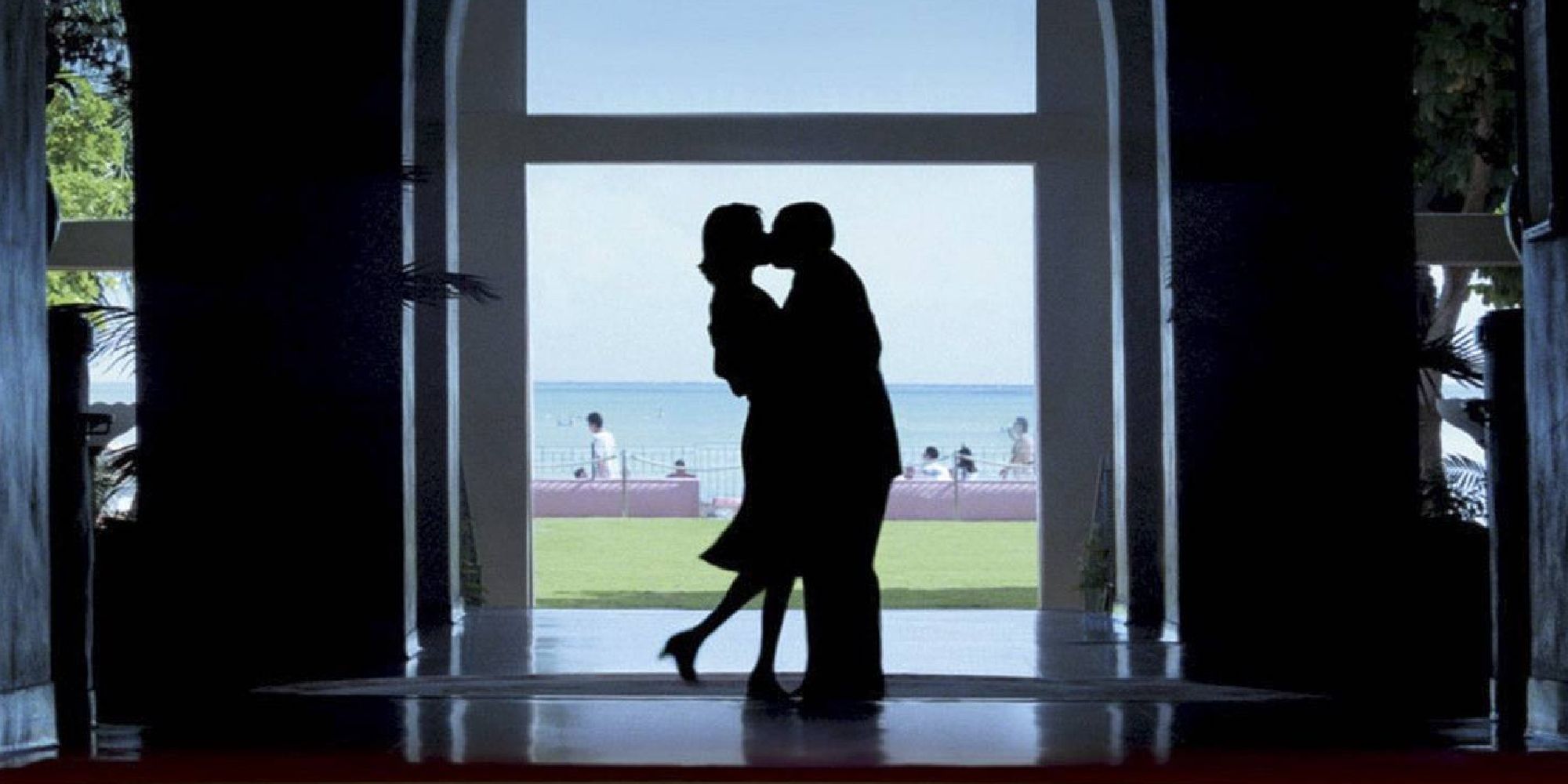 Adam Sandler and Emily Watson kissing in a doorway in Hawaii in Punch-Drunk Love