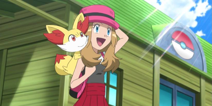 Pokemon anime Serena standing outside Pokemon Center with Fennekin on her back