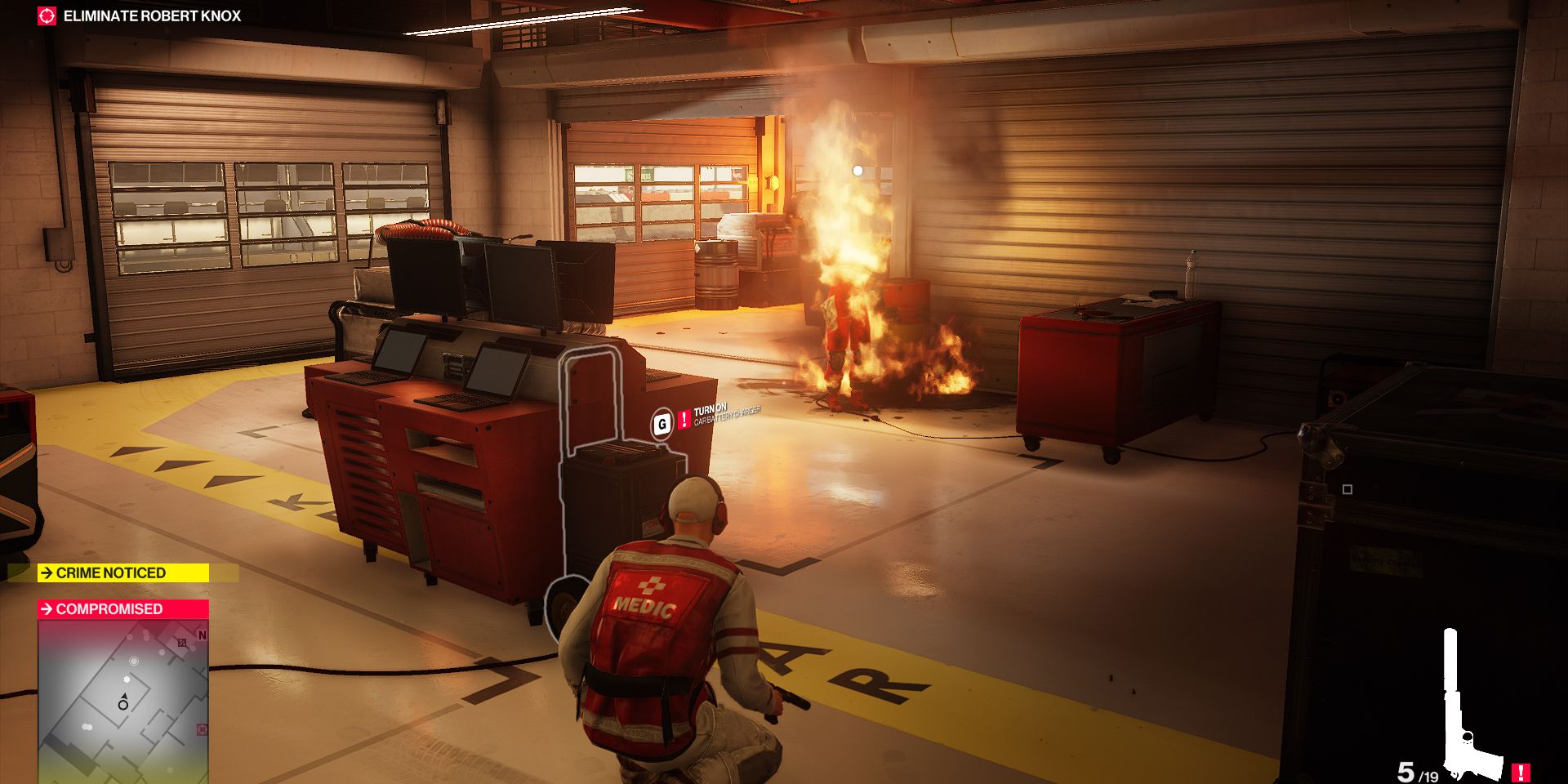 Agent 47 sets a mechanic on fire using a red barrel on the Miami level of Hitman 2