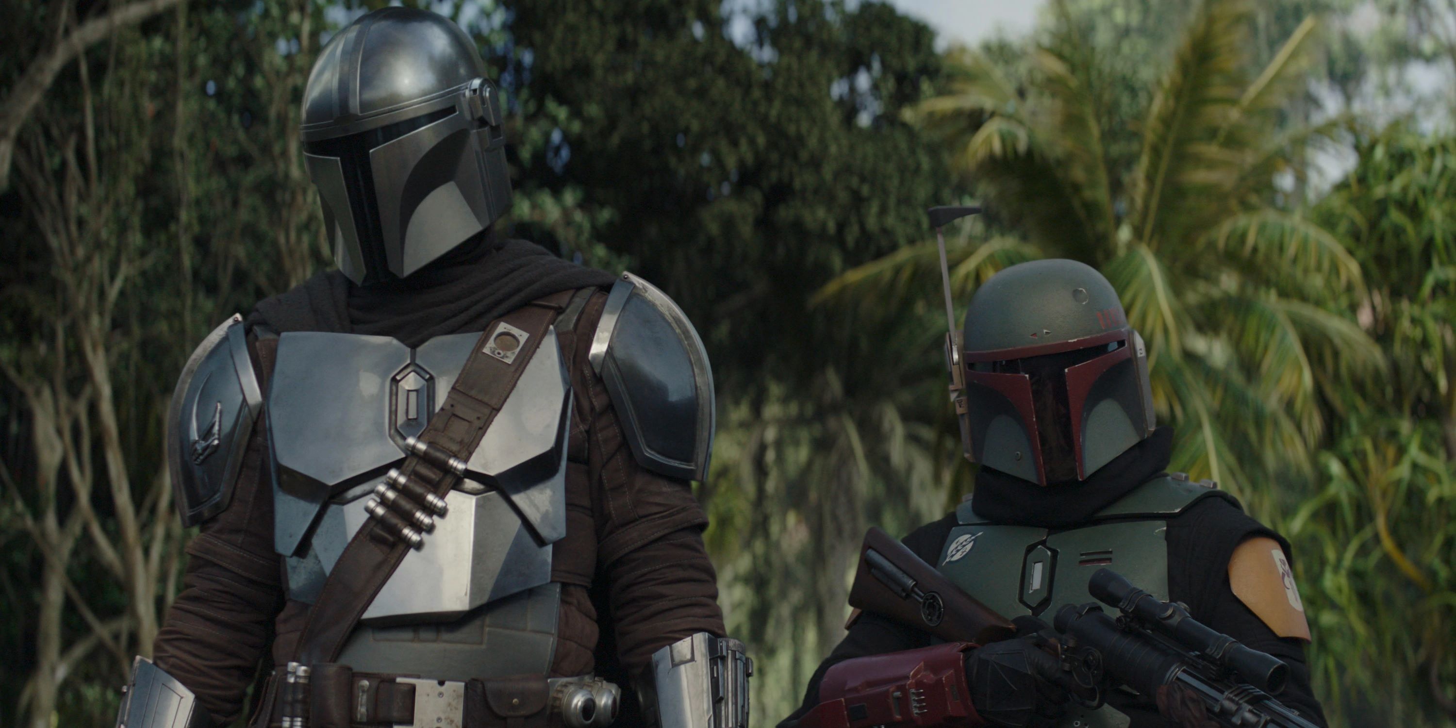 The Mandalorian standing next to Boba Fett in a forest