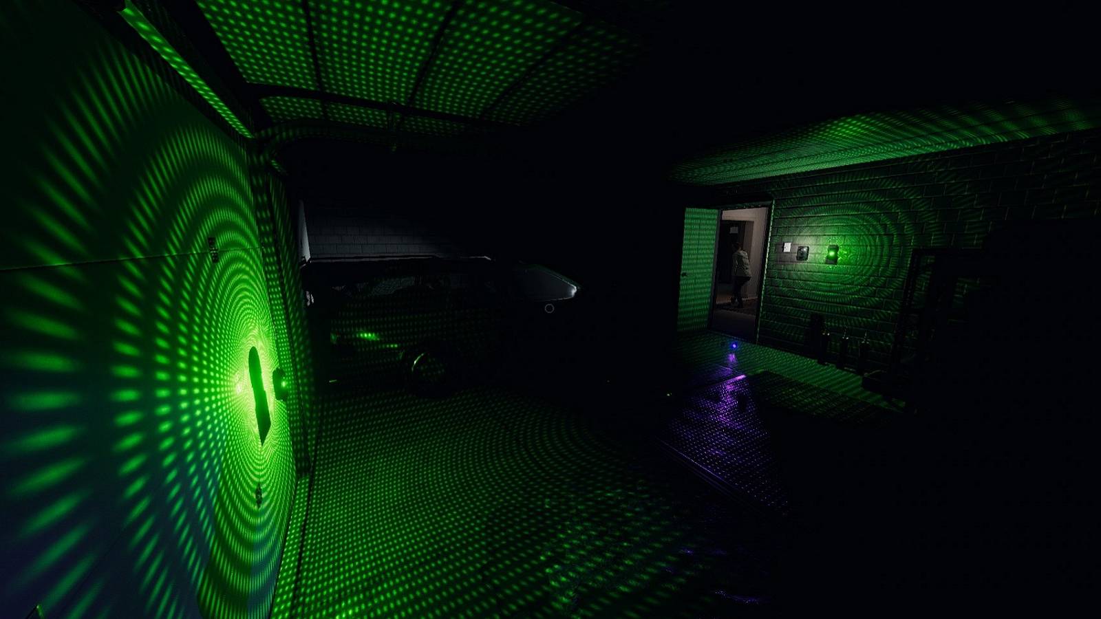Screenshot from Phasmophobia showing two D.O.T.S. projectors inside a garage.