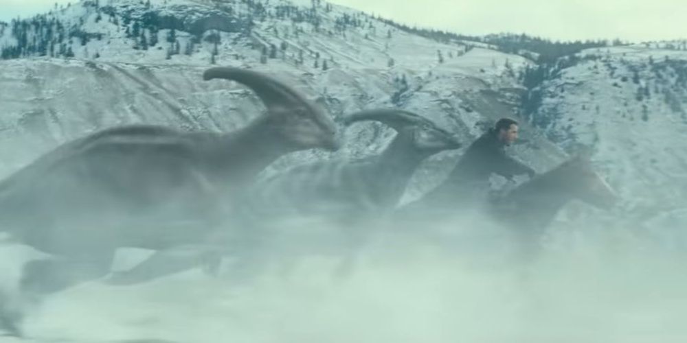 Image of a herd of Parasaurolophus running alongside Owen in Jurassic World: Dominion.