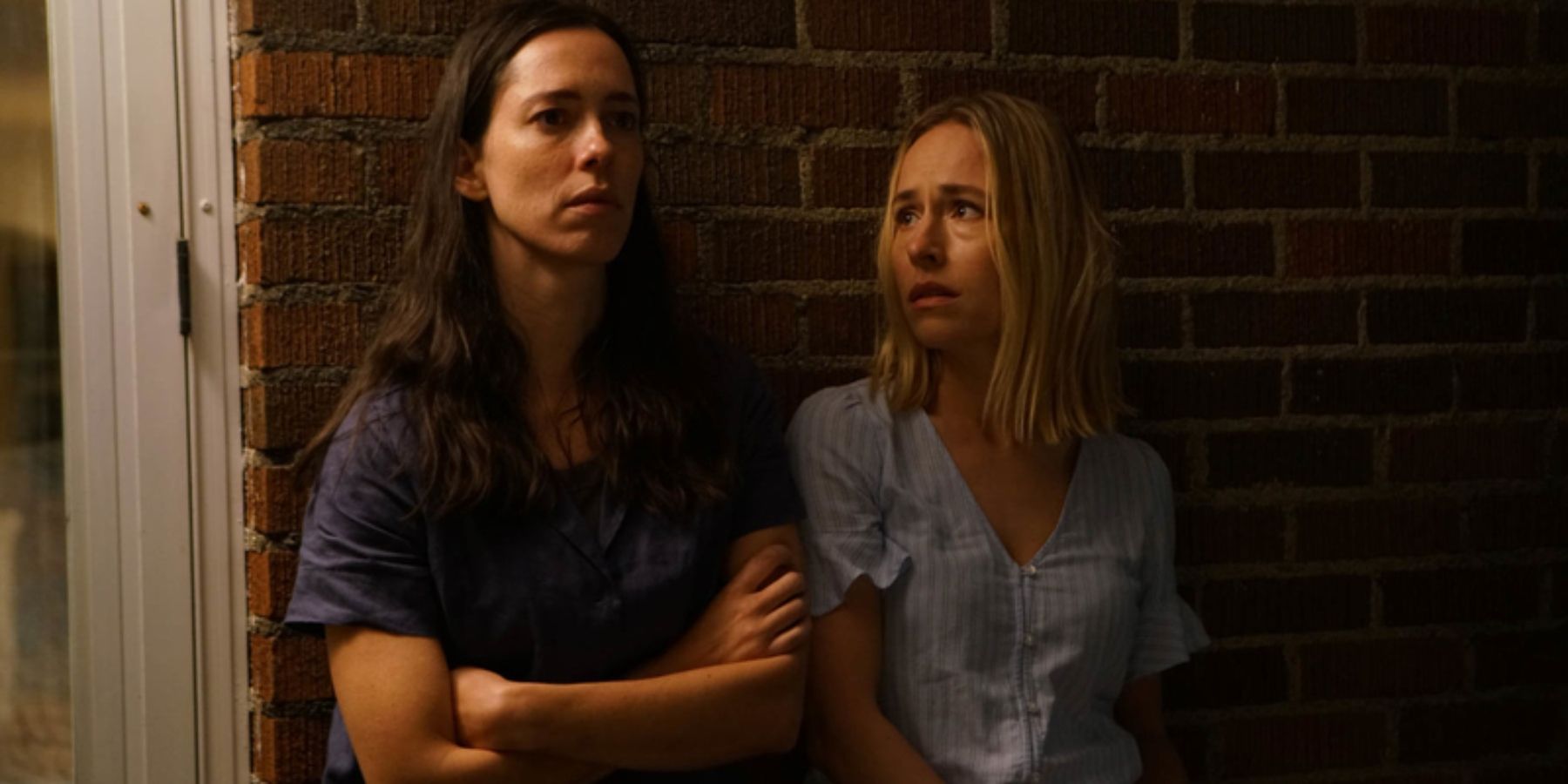 Beth (Rebecca Hall) and Claire (Sarah Goldberg) looking scared in The Night House
