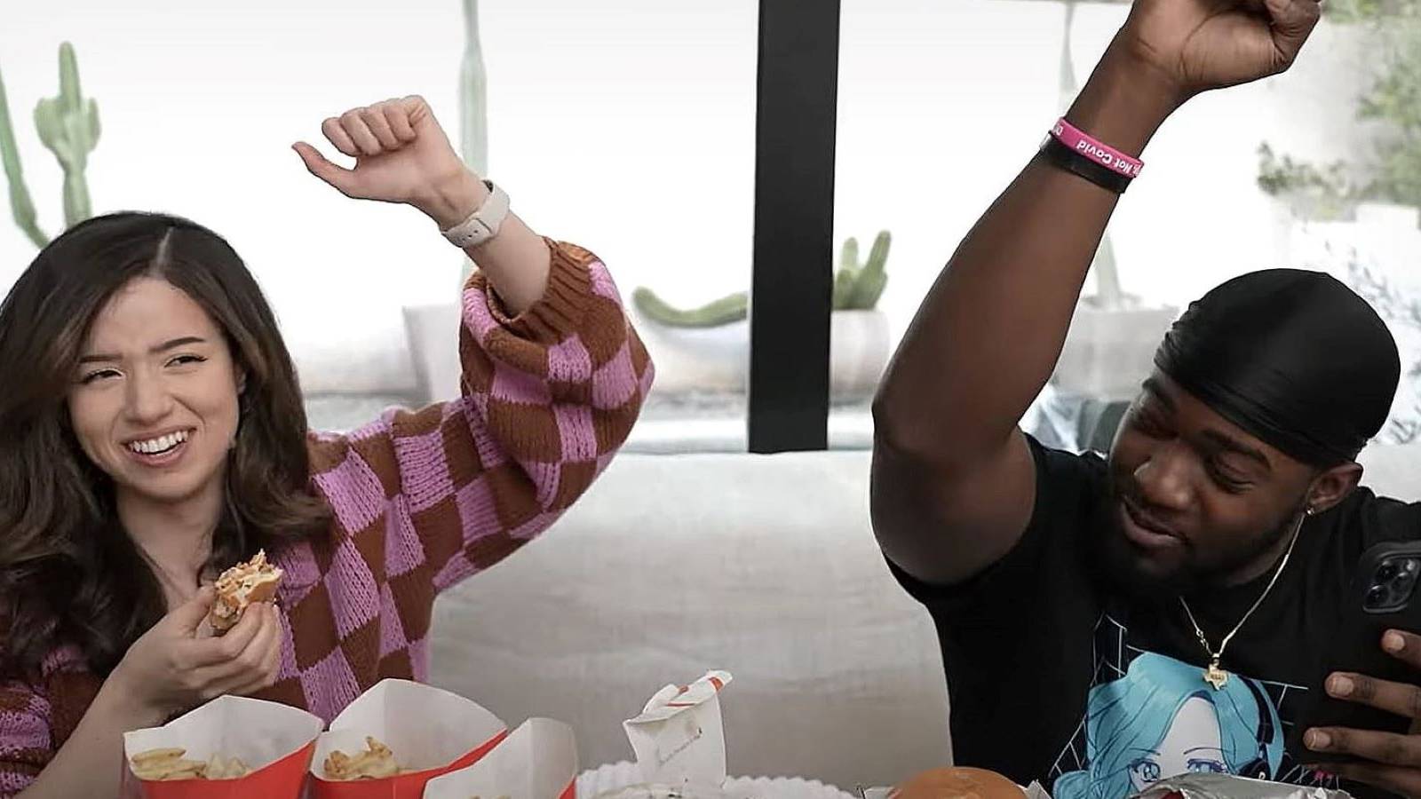 Pokimane and JiDion eating and raising their arms together in their YouTube collaboration video