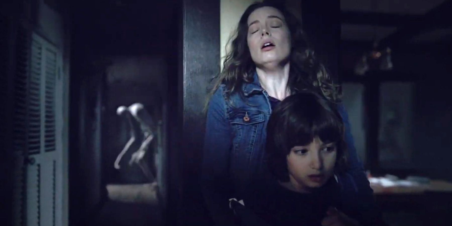 Gillian Jacobs as Sarah holding onto Azhy Robertson as Oliver in Come Play