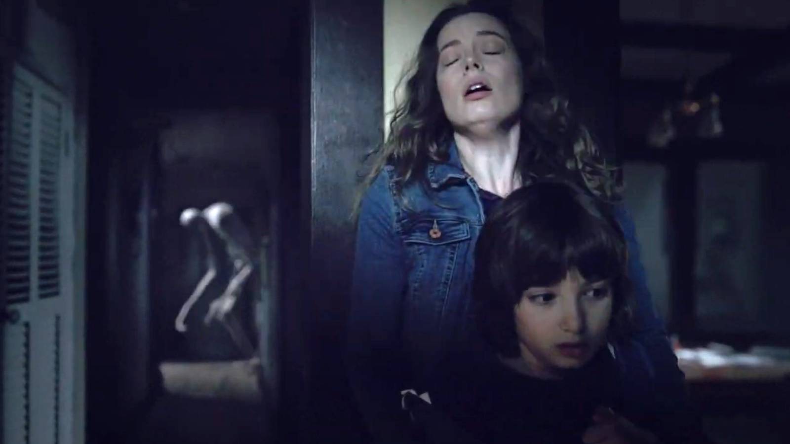 Gillian Jacobs as Sarah holding onto Azhy Robertson as Oliver in Come Play