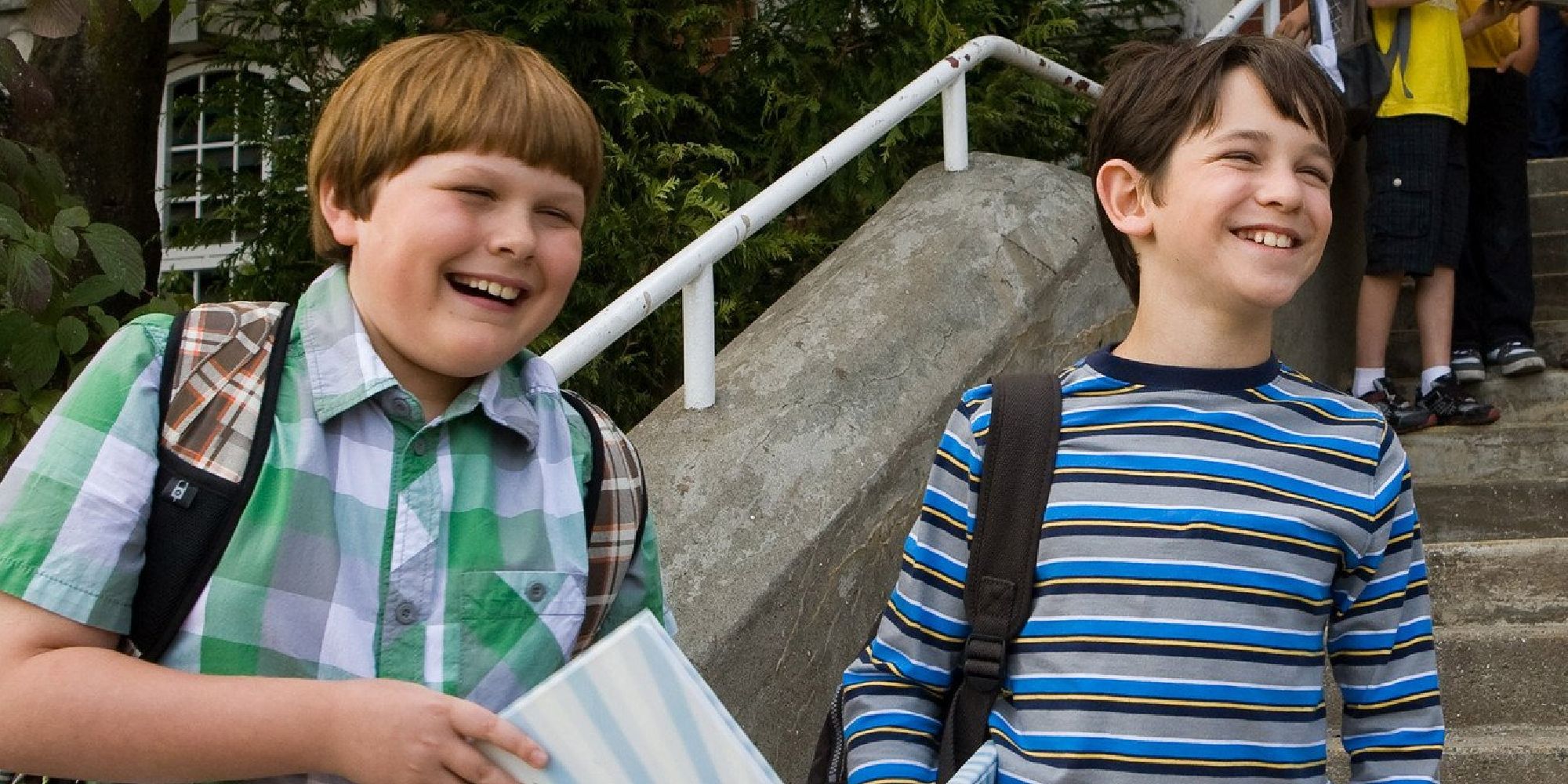 Greg and Rowley holding their middle school yearbooks in Diary of a Wimpy Kid