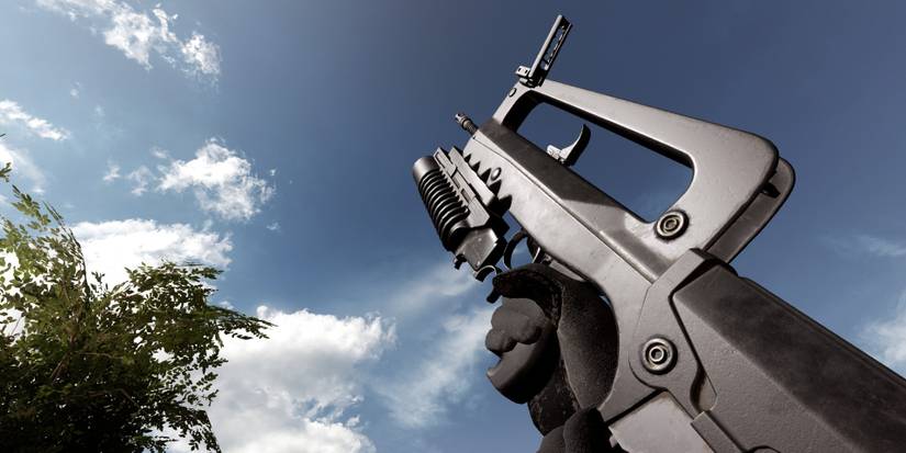 Insurgency Sandstorm first person image of soldier holding FAMAS assault rifle towards blue sky