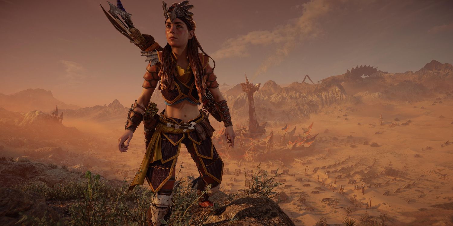aloy standing on a ridge in a flashy outfit with a feathered headress overlooking a town with a large spire in the middle