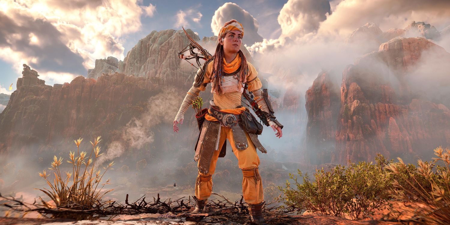 aloy in a yellow, loose fitting outfit with a utility belt and a headband standing in front of foggy mountains 