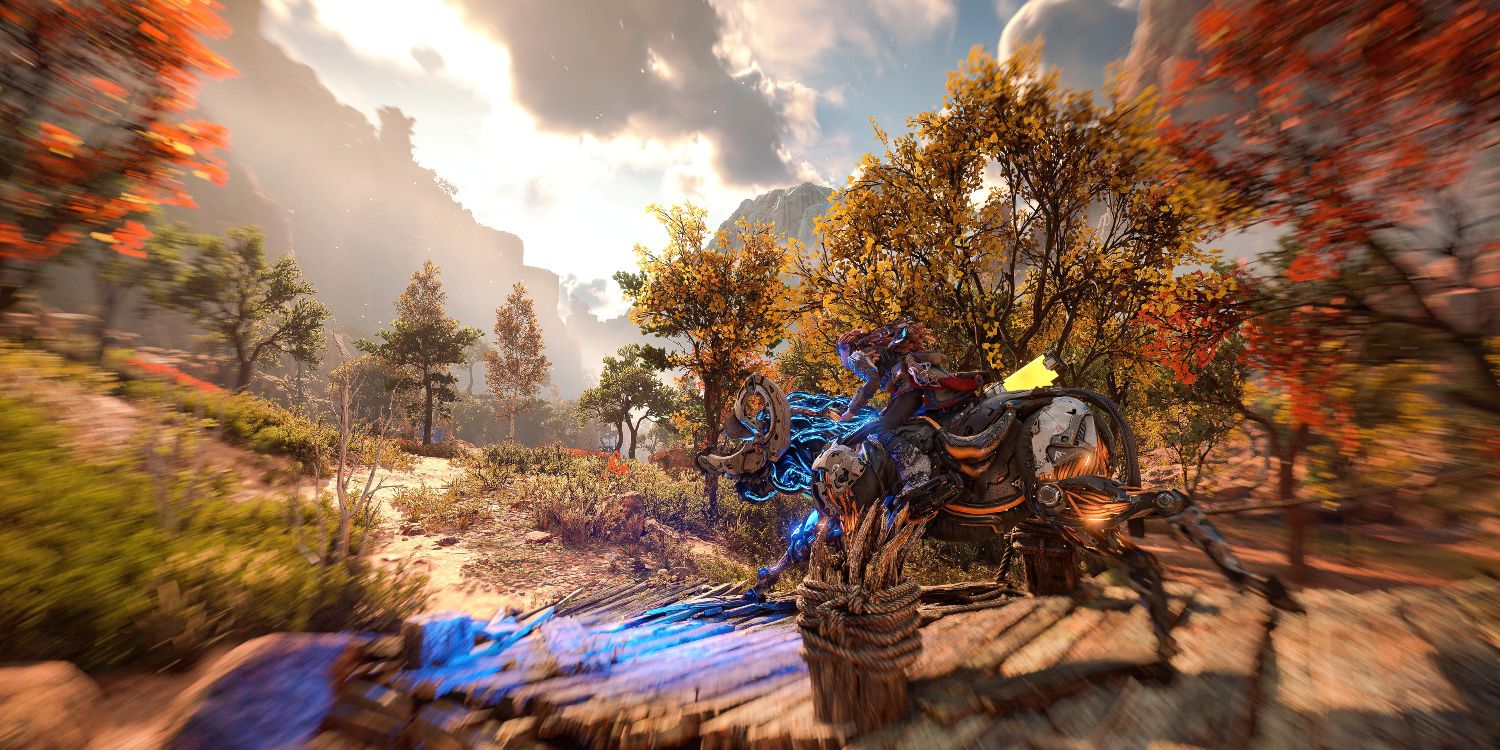 aloy on a charger machine riding over a small wooden bridge flanked by trees with orange and red leaves 
