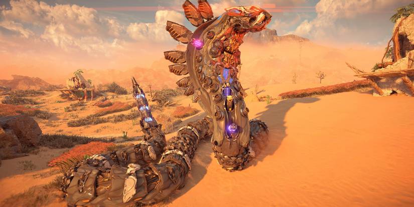 a large, snake machine with metal plates in the shape of a cobra's hood slithers over sandy dunes in a desert