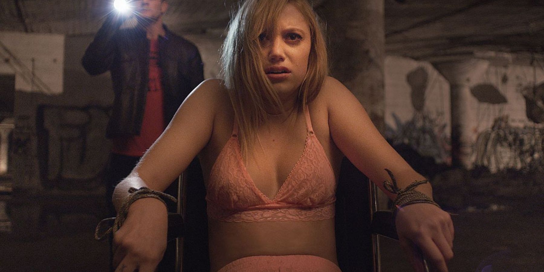 Jay (Maika Monroe) sitting in a chair looking scared in It Follows