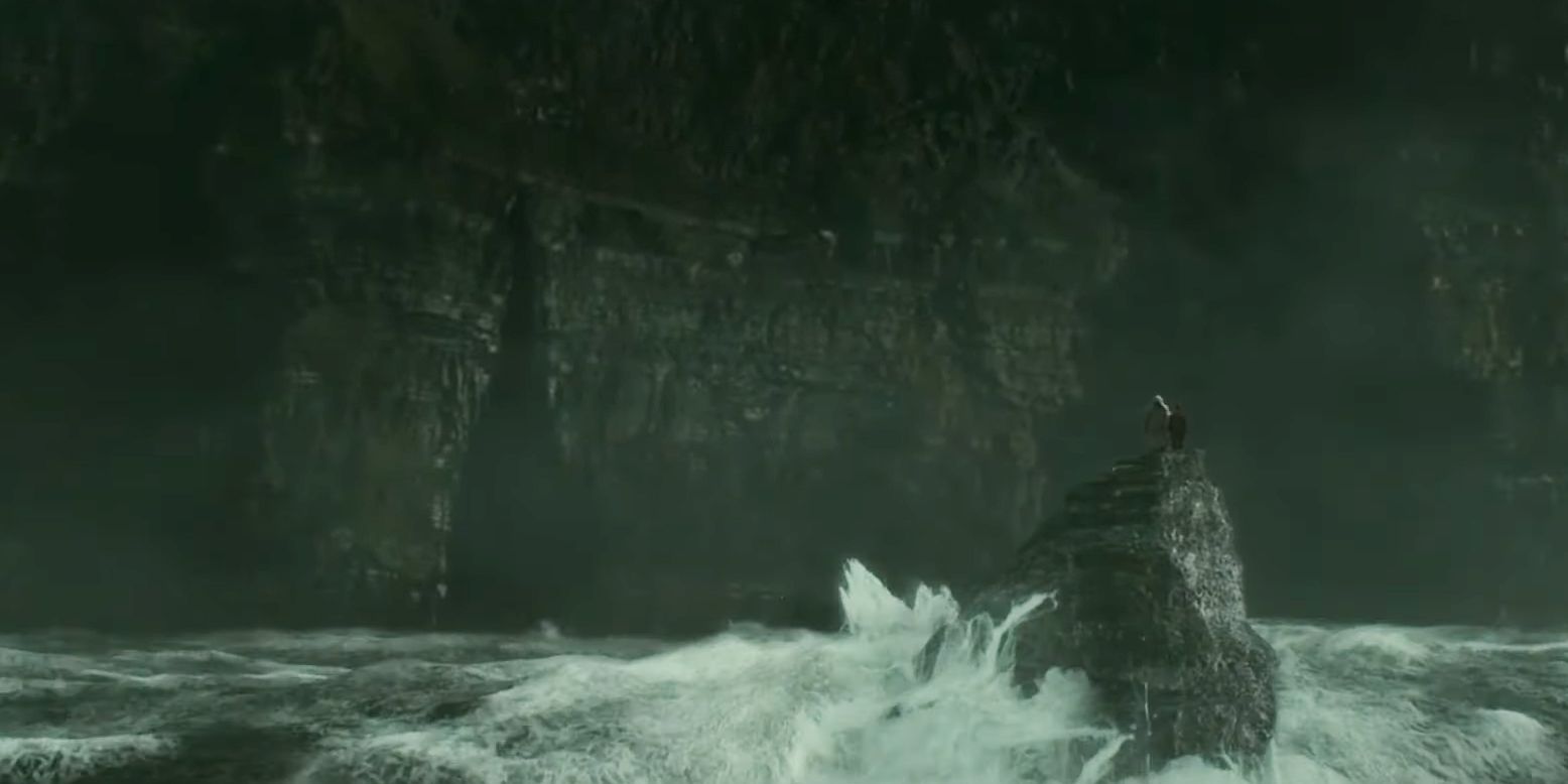 Дамблдор и Гарри Поттер стоят на скале в бушующем море, а перед ними пещера в Утесах Мохер в «Принце-полукровке».