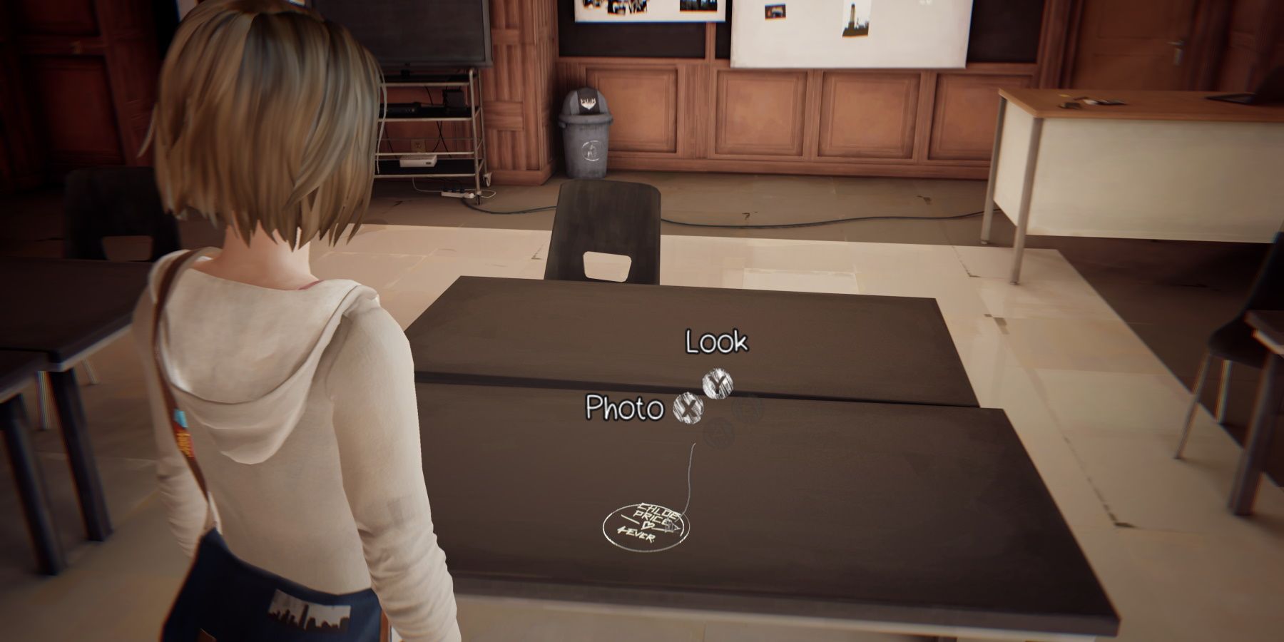 Max looking at graffiti eteched on a table in Mr Jefferson's classroom during episode 5 of Life is Strange