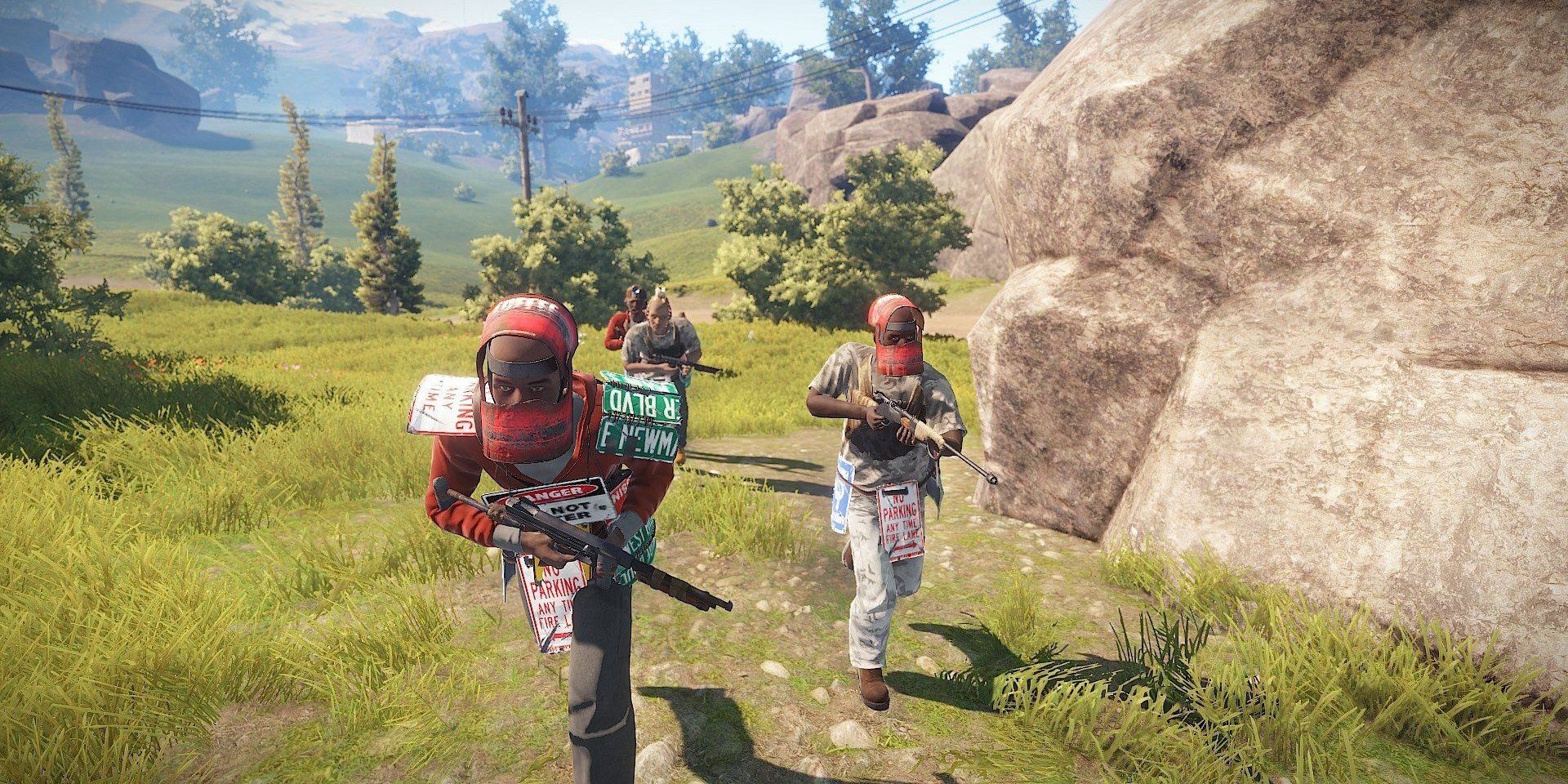 Players dressed in post apocalyptic gear made out of scrap rush past a boulder in the survival game Rust