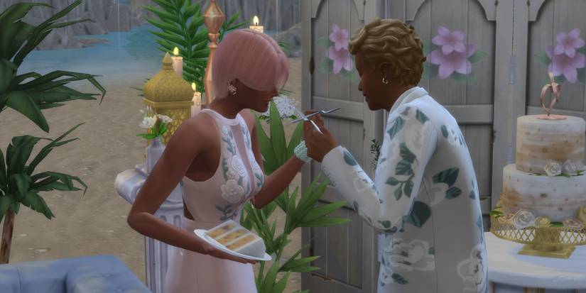 Two newly weds feeding each other cake at their wedding in The Sims 4: My Wedding Stories