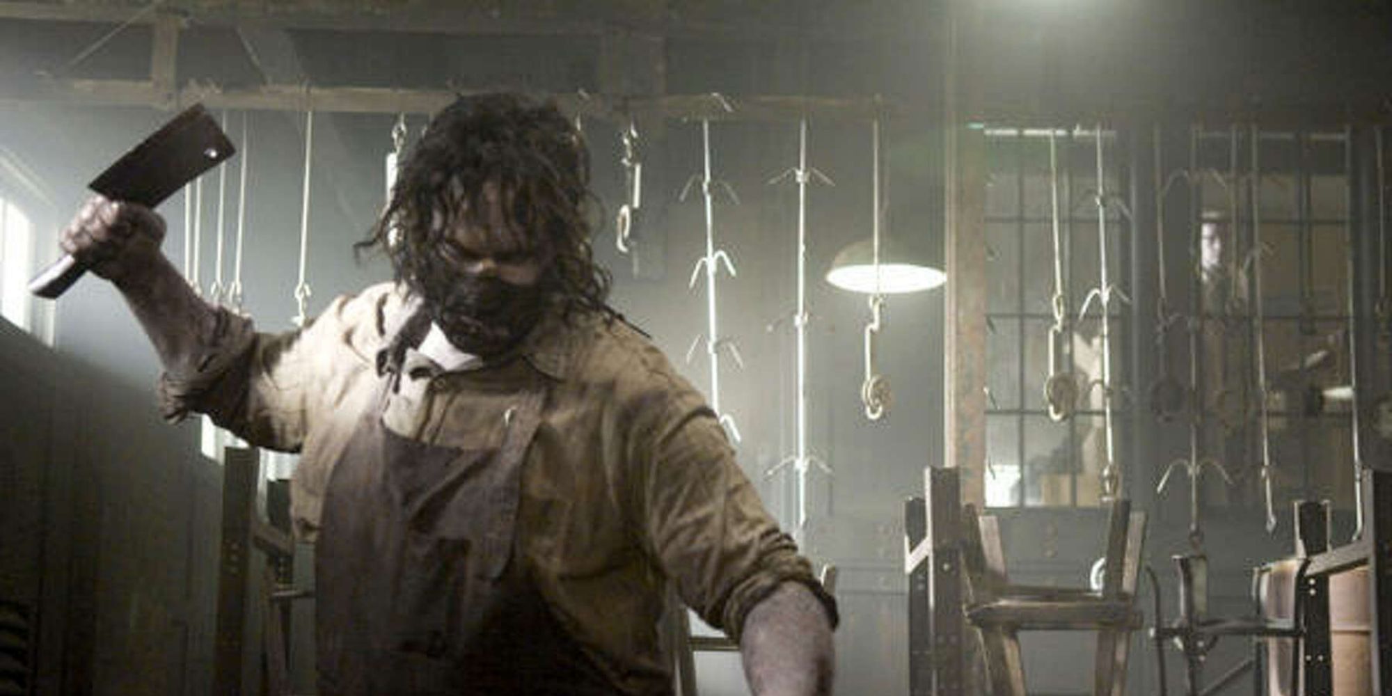 The Slaughterhouse Manager watches Leatherface chop meat in ​​​​​​​The Texas Chainsaw Massacre: The Beginning