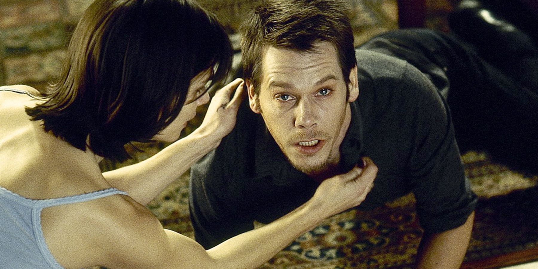 Maggie (Kathryn Erbe) and Tom (Kevin Bacon) looking scared in Stir Of Echoes