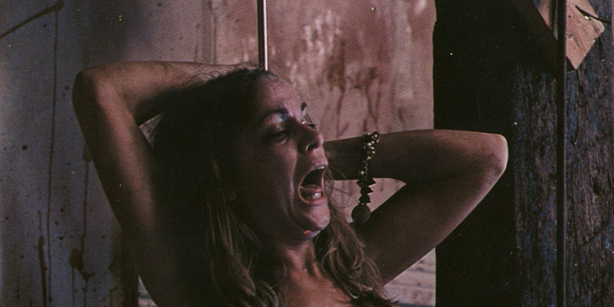 Character struggling on a meat hook in The Texas Chain Saw Massacre