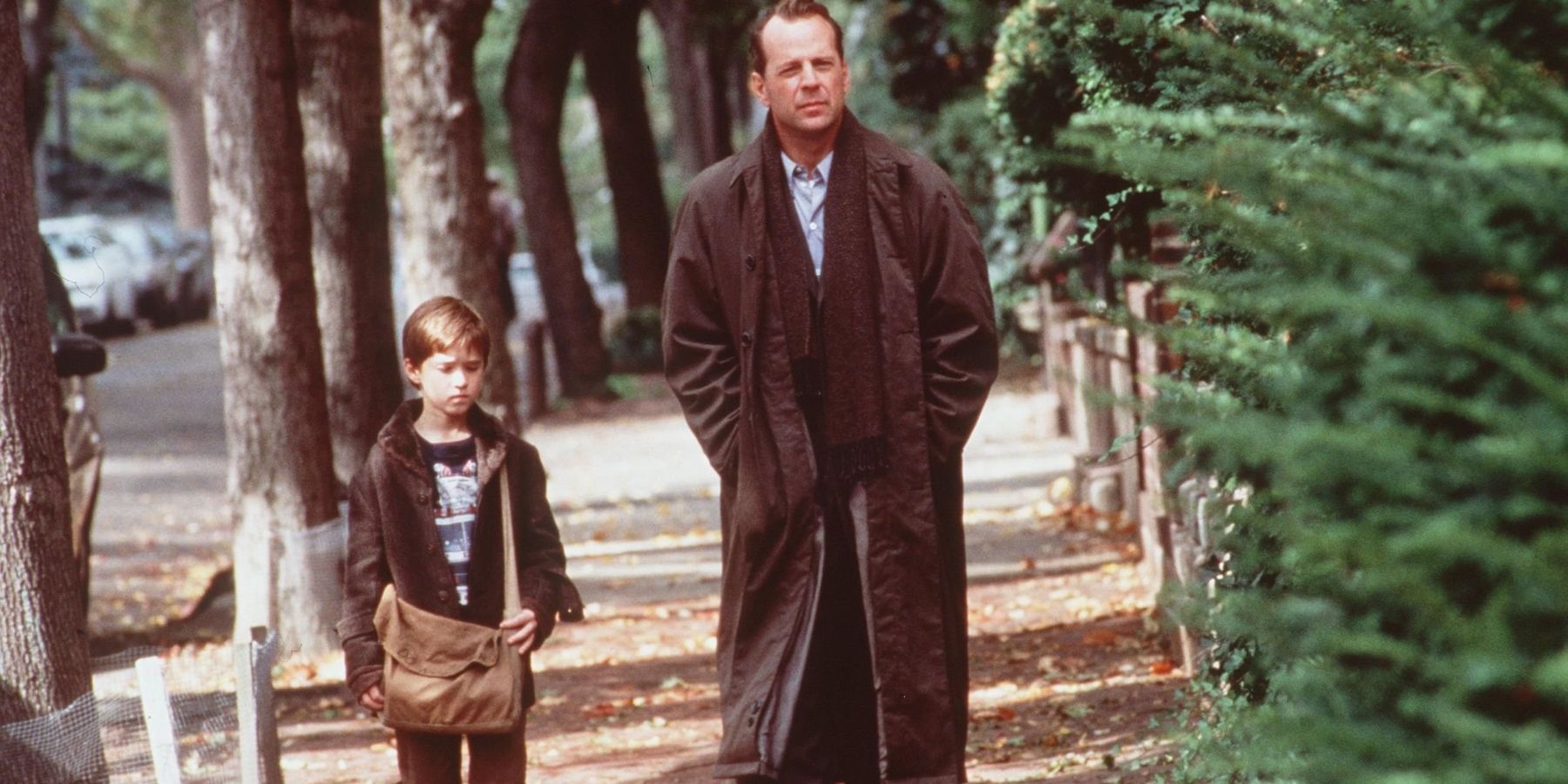 Haley Joel Osment as Cole and Bruce Willis as Malcolm walking outside together in The Sixth Sense
