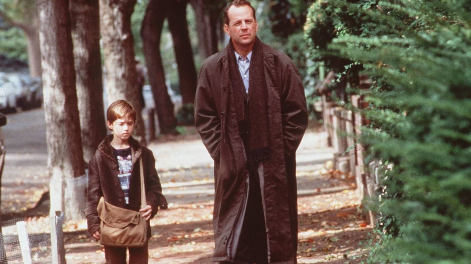 Haley Joel Osment as Cole and Bruce Willis as Malcolm walking outside together in The Sixth Sense
