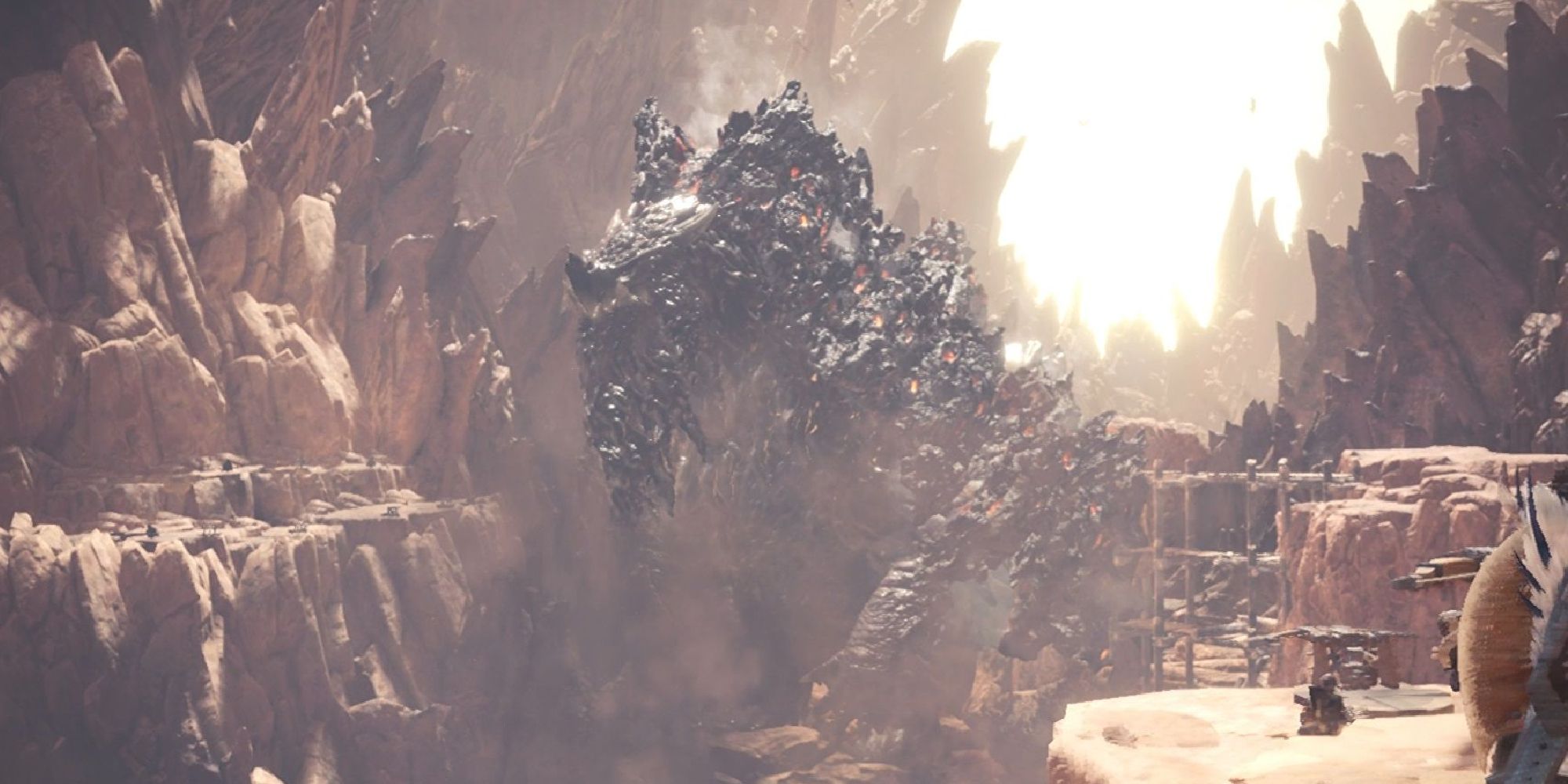 A Zorah Magdoros marching through a canyon while Hunters watch in Monster Hunter World