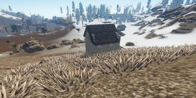 Several Wooden Floor Spikes near a base in Rust. 