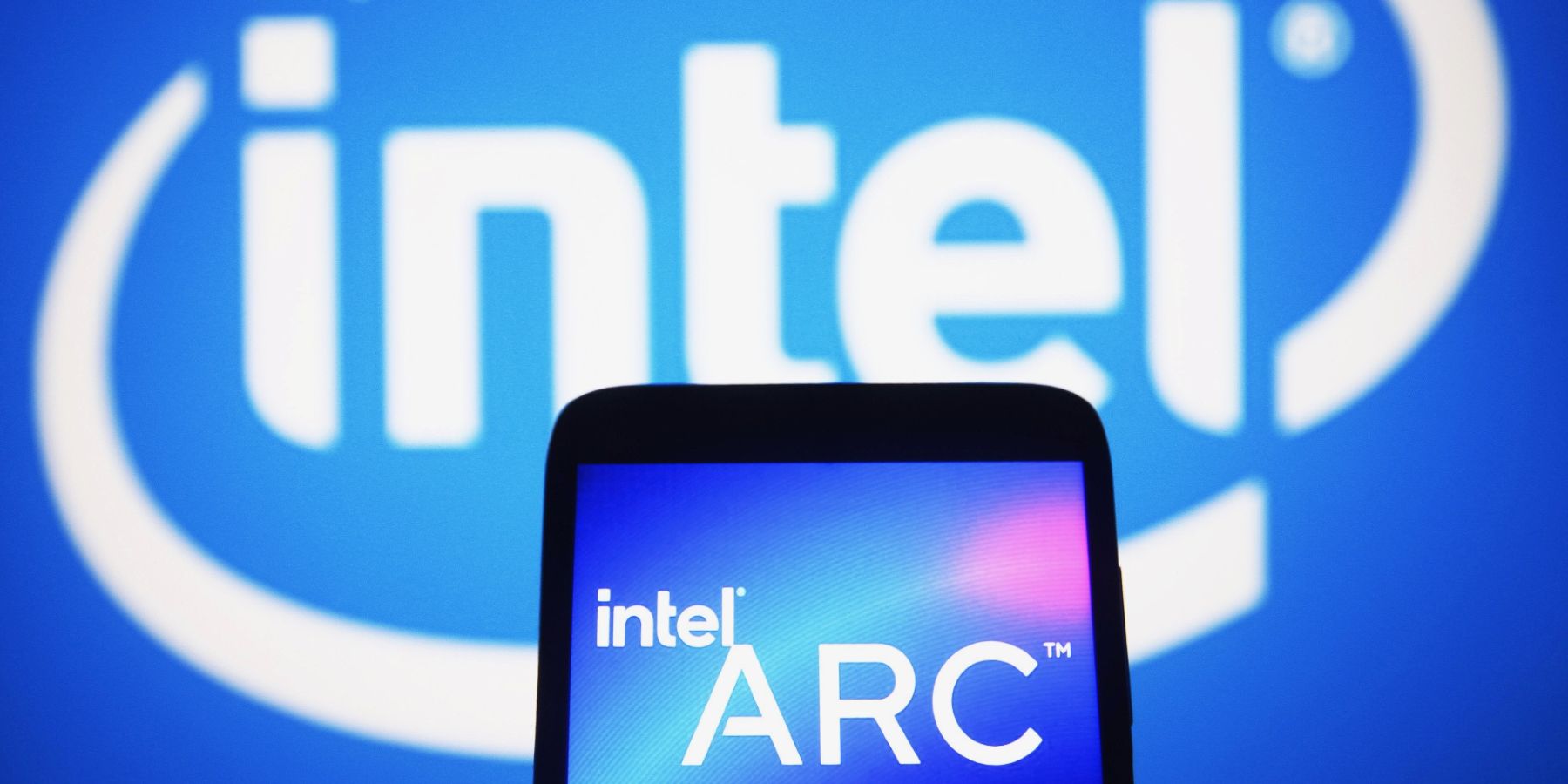 Image of a phone screen showing the Intel Arc logo with the main Intel logo in the background.
