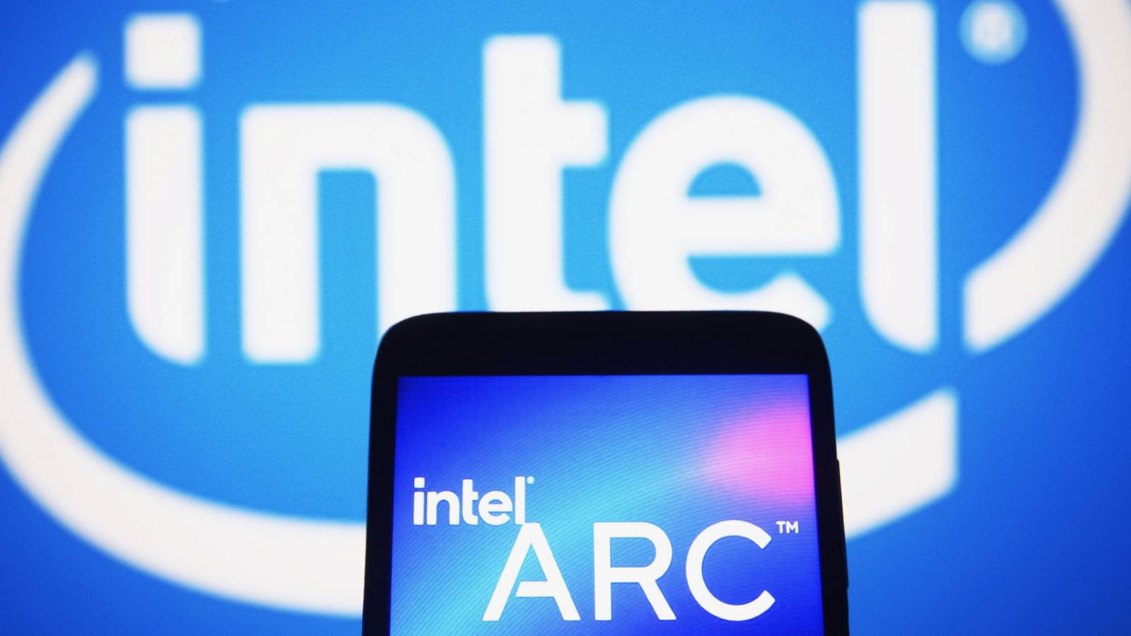 Image of a phone screen showing the Intel Arc logo with the main Intel logo in the background.